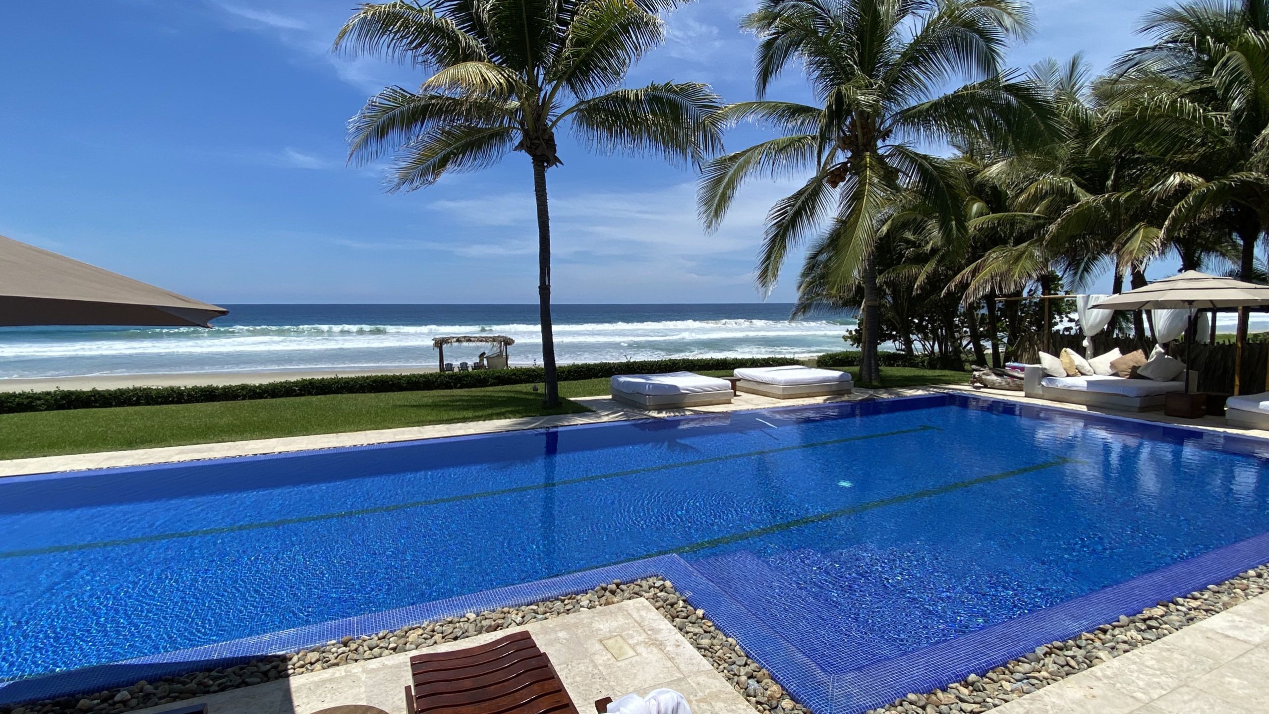 Casa Emelina oceanfront with big private pool, palm trees and ocean in the background. 